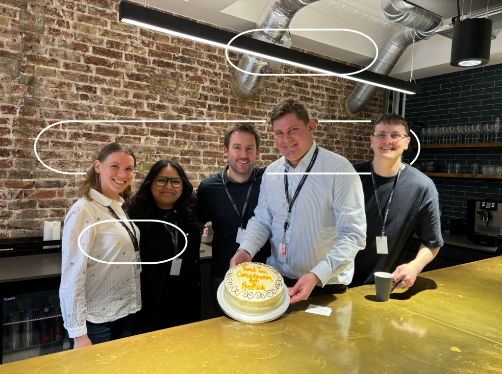 CoreStream GRC team holding a thank you cake gifted by clients with CoreStream GRC logo overlay